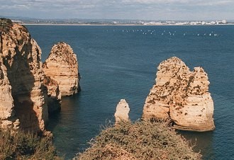 Felsformation an der Algarve-Küste ragt aus dem Wasser Felsformation an der Algarve-Küste ragt aus dem Wasser